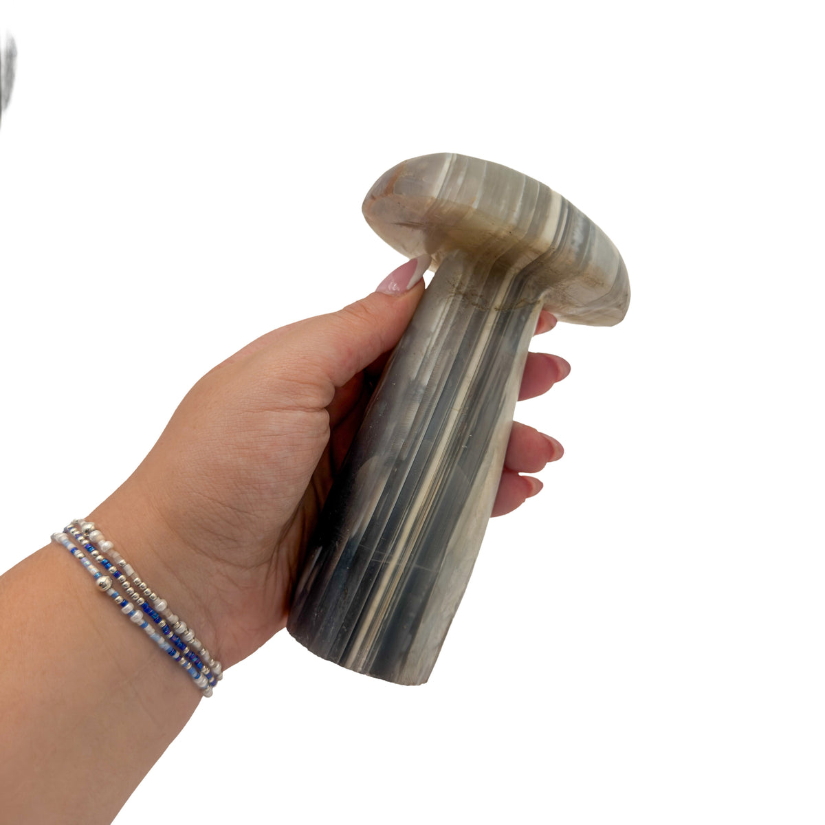 Agate mushroom no. 2 held in an open hand, showing the true scale of this 5.66 inch, 1.51 pound carving.