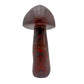Right profile of a hand-carved tiger iron mushroom, metallic grey hematite layers between red and gold.