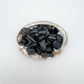 Top-down shot of Black Tourmaline raw stone, kept close for Protection, showing natural form.