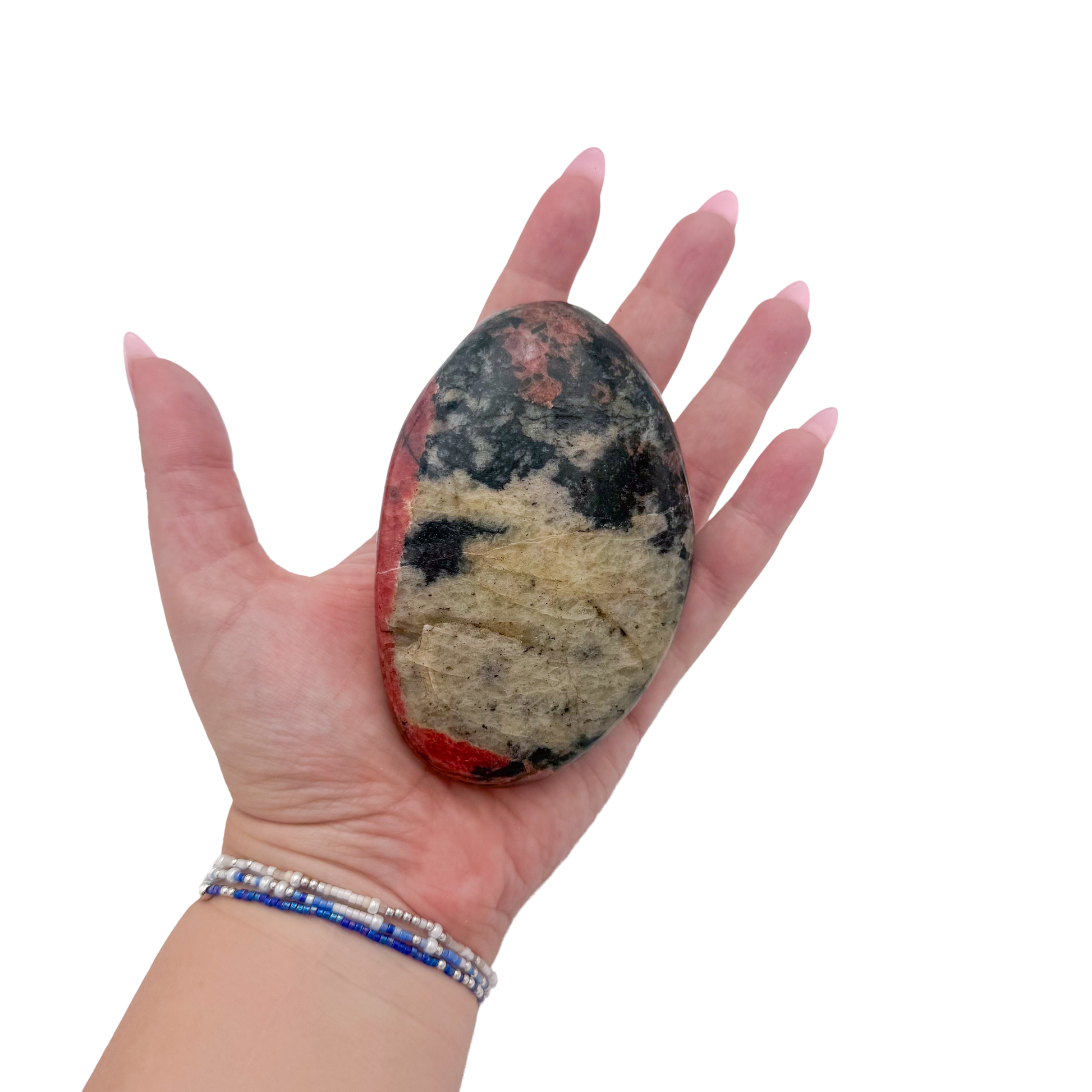 Rhodonite polished free form from Zimbabwe held in hand to show scale