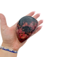 Rhodonite polished free form from Zimbabwe held in hand to show scale