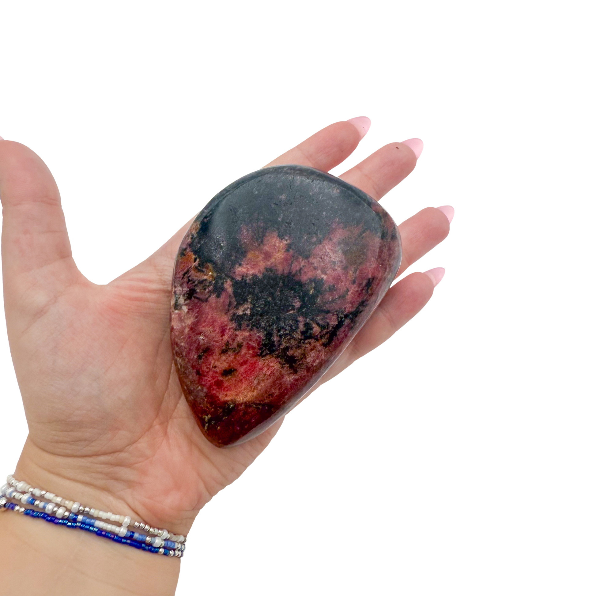Rhodonite polished free form from Zimbabwe held in hand to show scale