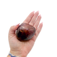 Rhodonite polished free form from Zimbabwe held in hand to show scale