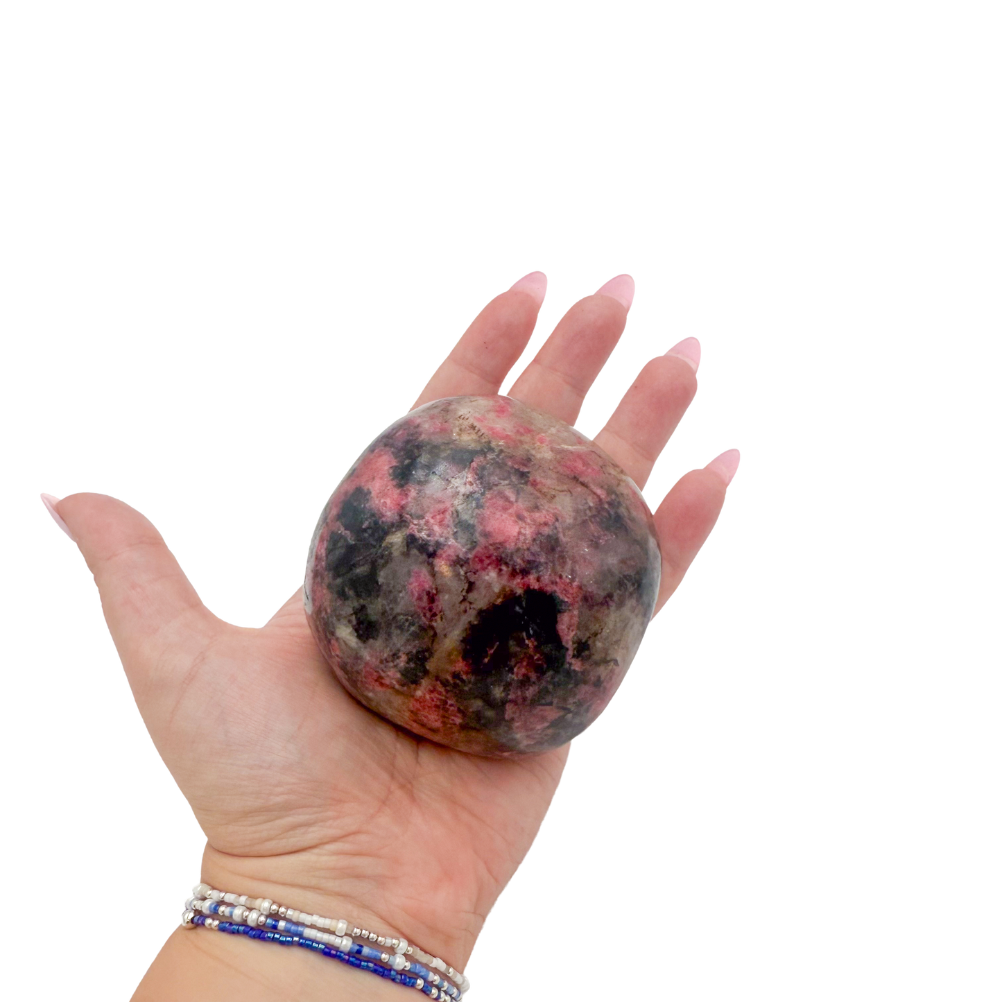 Rhodonite polished free form from Zimbabwe held in hand to show scale