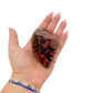 Rhodonite polished free form from Zimbabwe held in hand to show scale