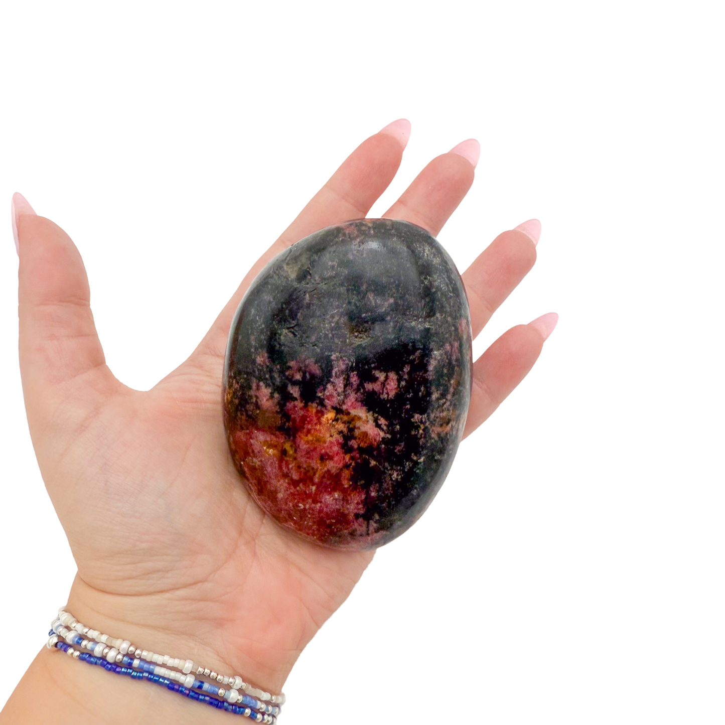 Rhodonite polished free form from Zimbabwe held in hand to show scale