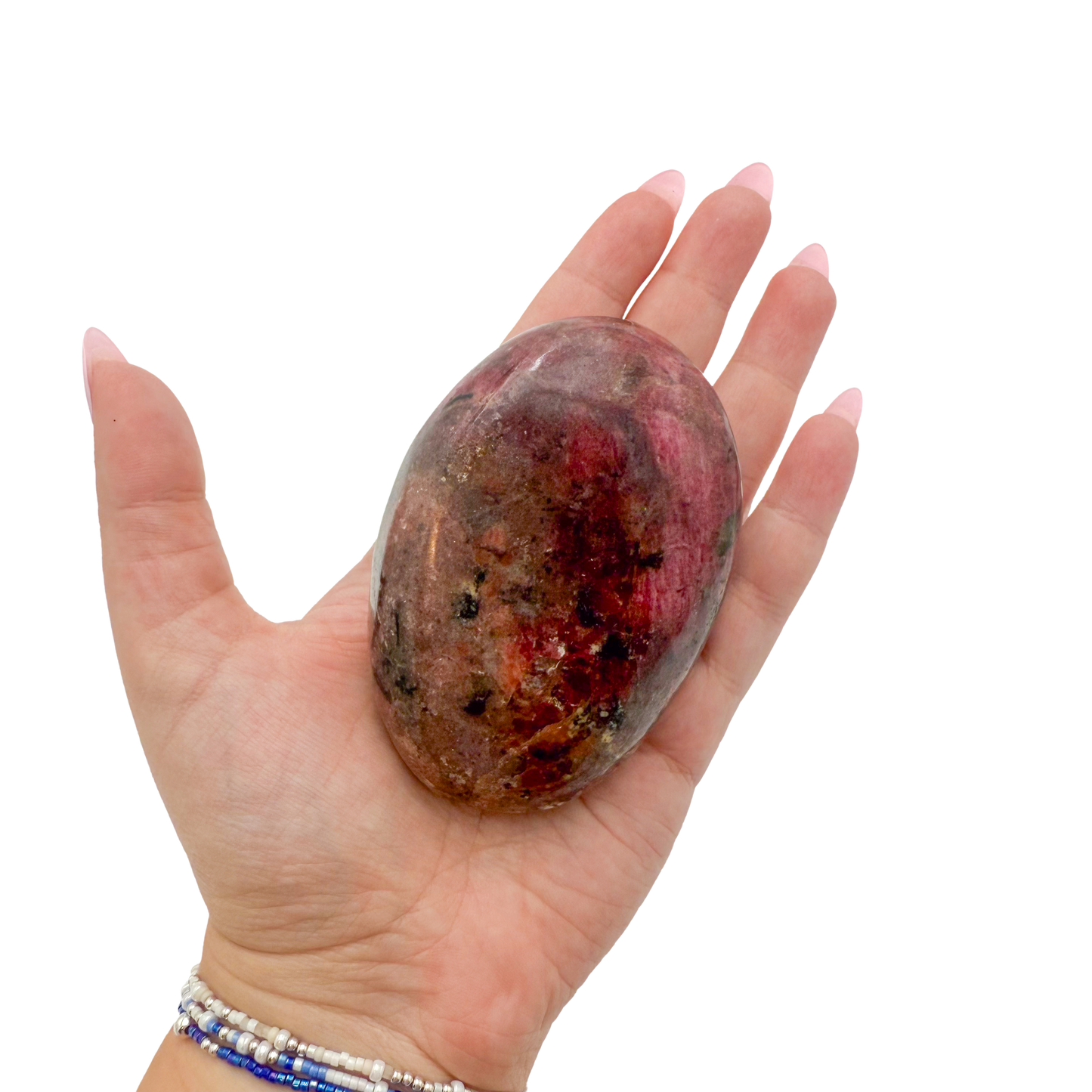 Rhodonite polished free form from Zimbabwe held in hand to show scale