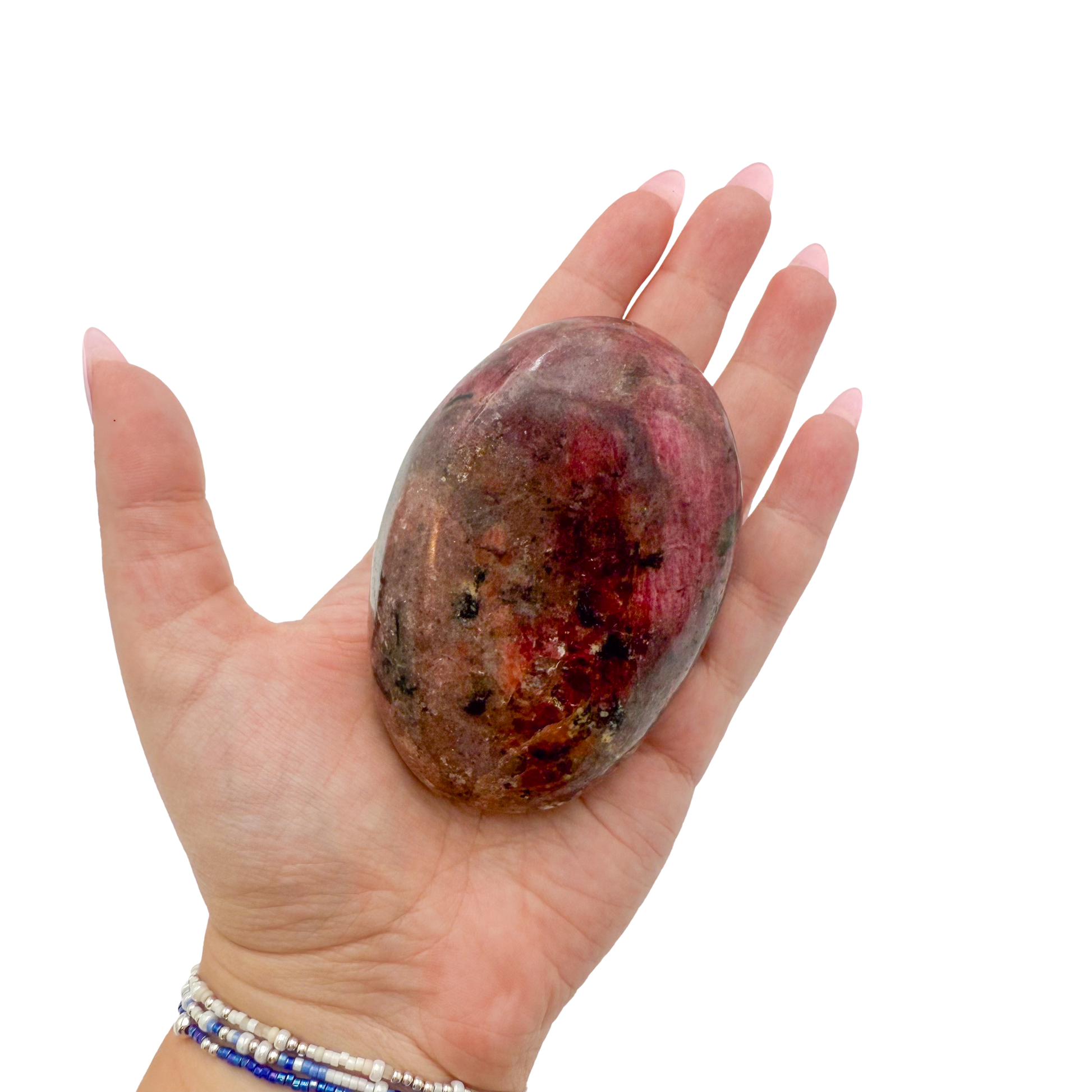 Rhodonite polished free form from Zimbabwe held in hand to show scale