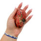 Rhodonite polished free form from Zimbabwe held in hand to show scale