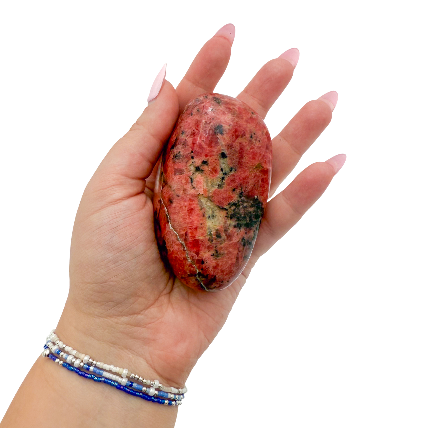 Rhodonite polished free form from Zimbabwe held in hand to show scale