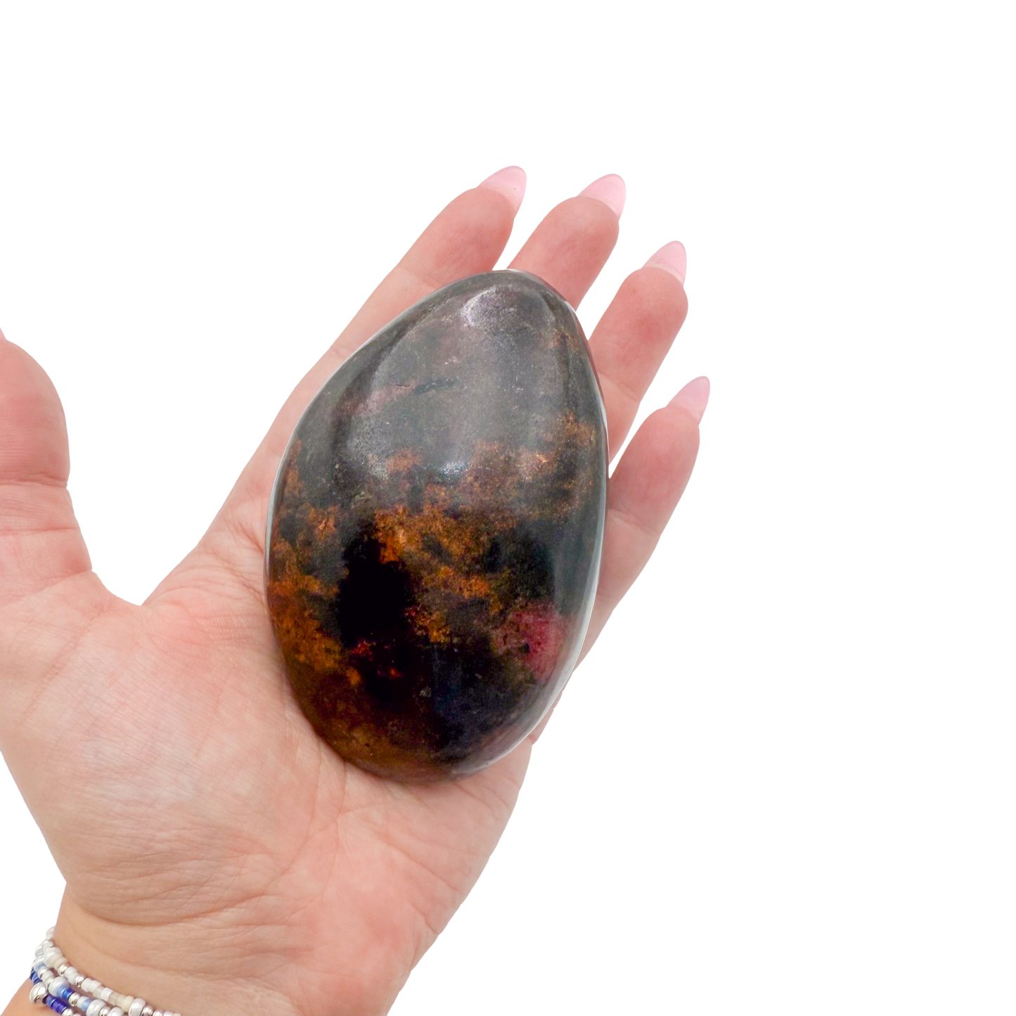 Rhodonite polished free form from Zimbabwe held in hand to show scale