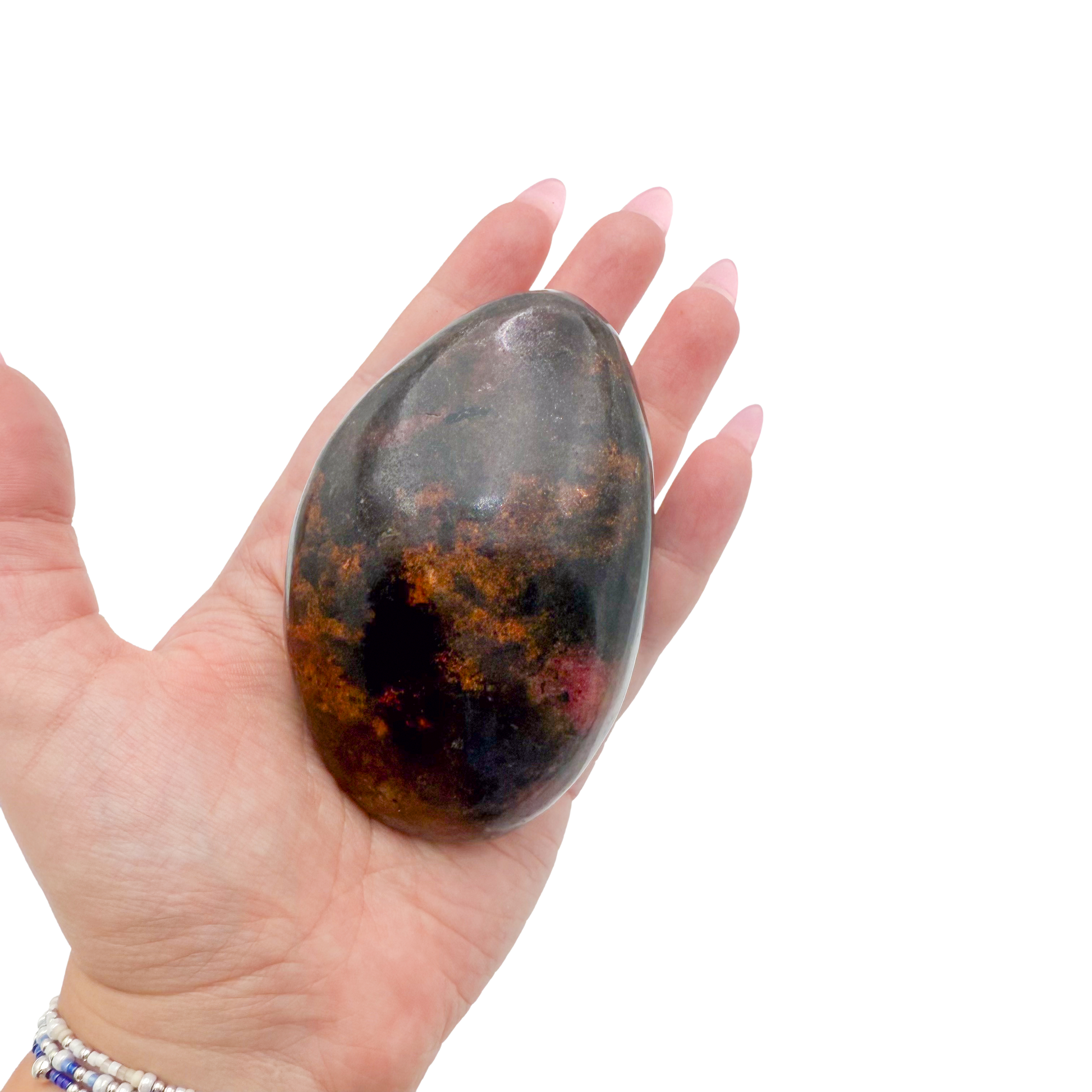 Rhodonite polished free form from Zimbabwe held in hand to show scale