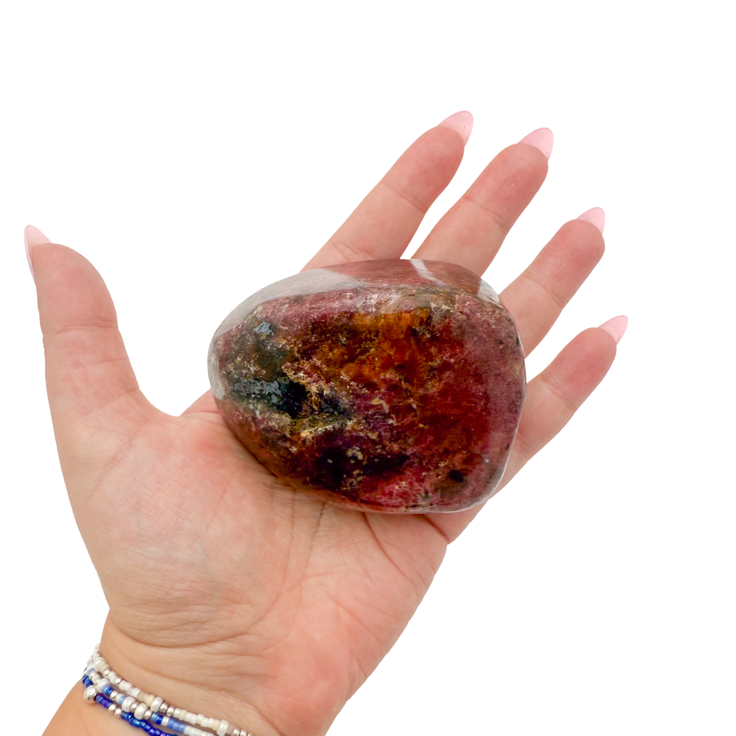 Rhodonite polished free form from Zimbabwe held in hand to show scale