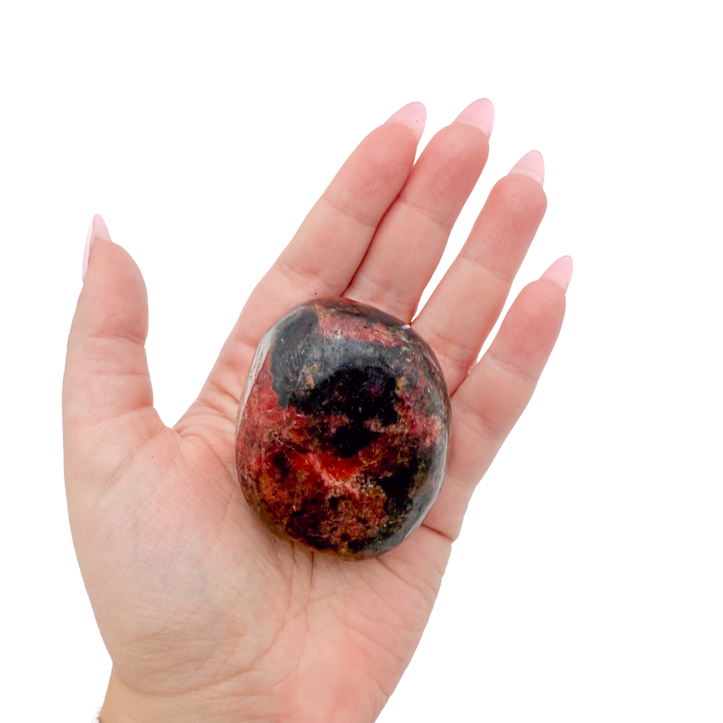 Rhodonite polished free form from Zimbabwe held in hand to show scale