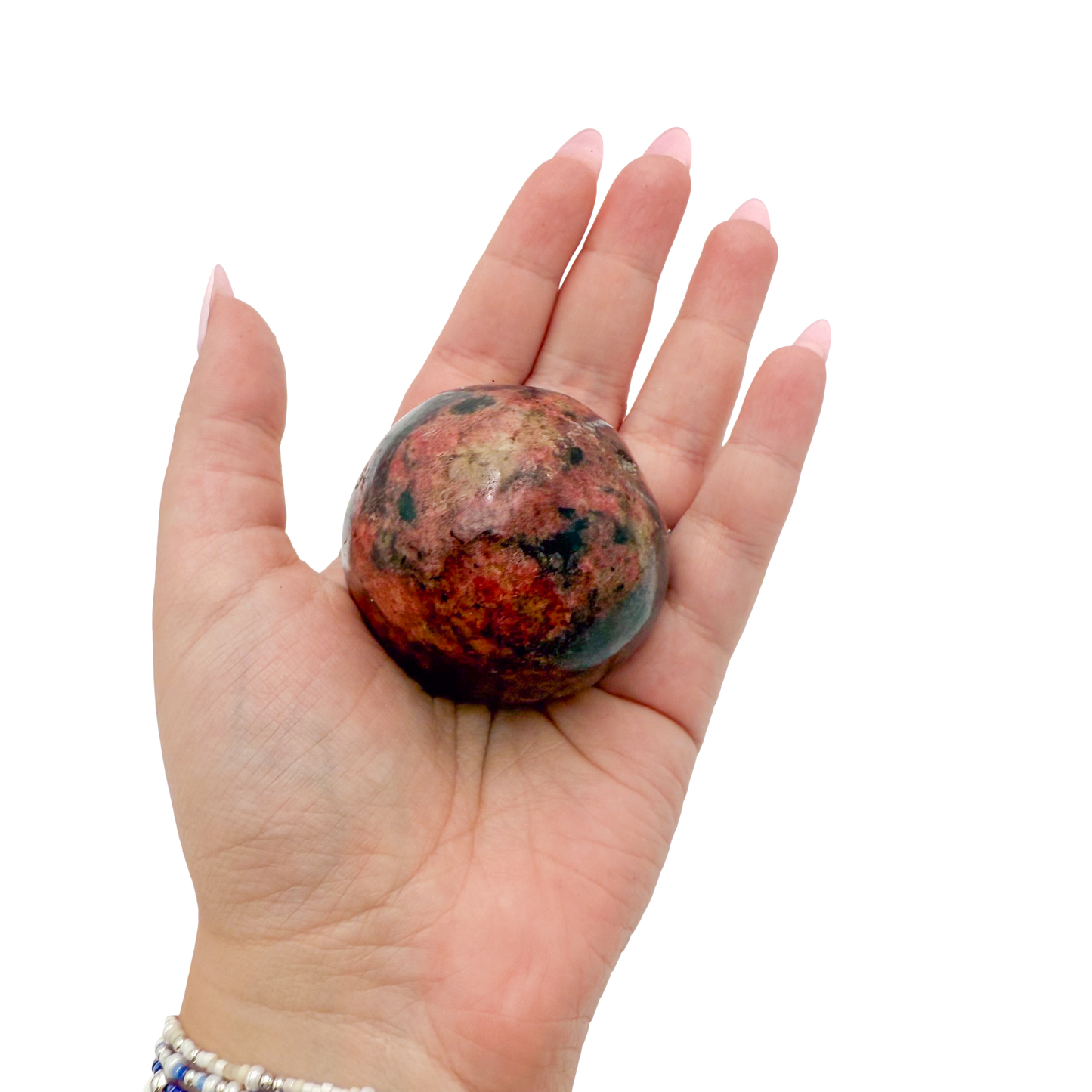 Rhodonite polished free form from Zimbabwe held in hand to show scale