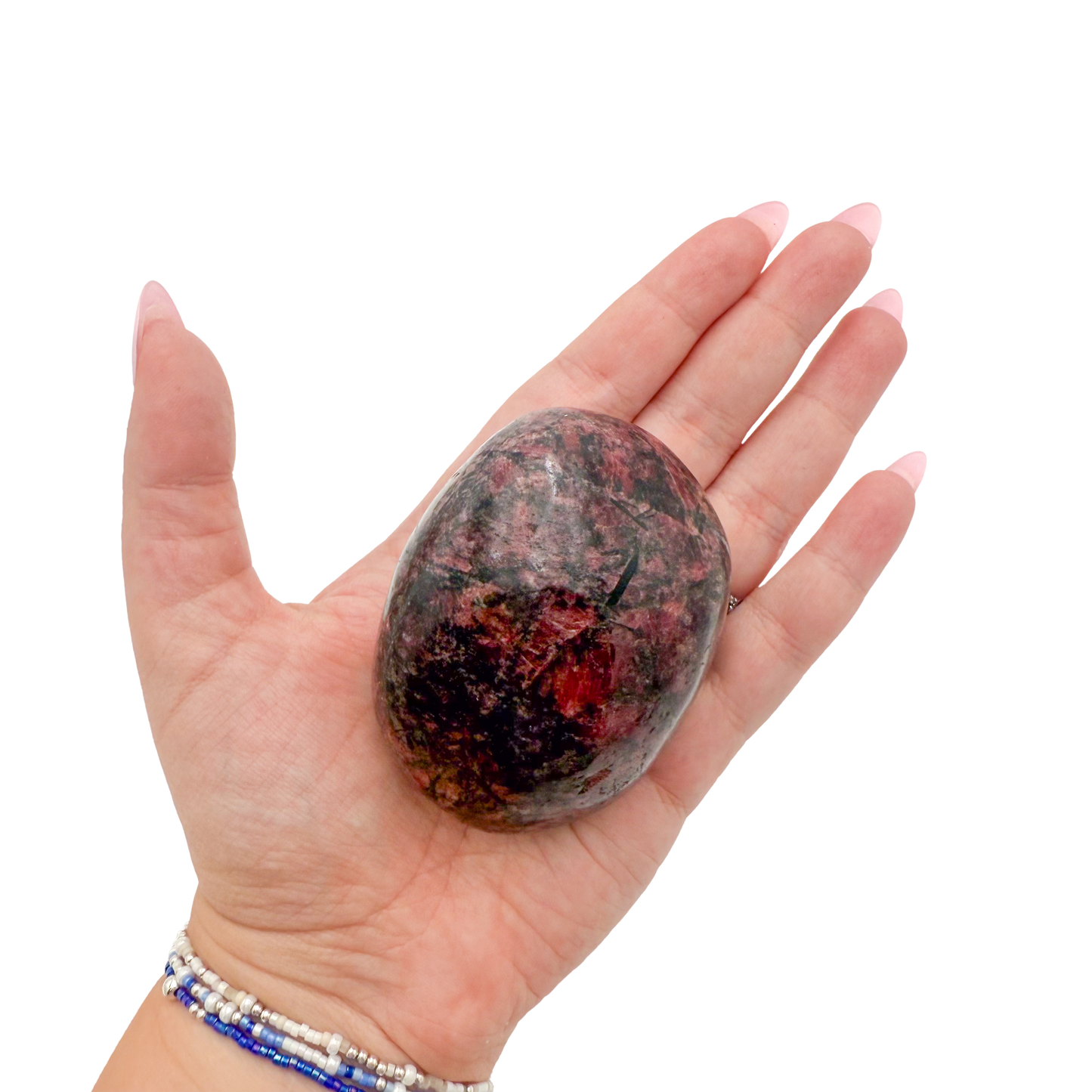Rhodonite polished free form from Zimbabwe held in hand to show scale