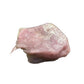 In-hand view of a Rose Quartz specimen held against natural backdrop.