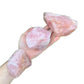 Detail capture of Rose Quartz raw stone, showing earthy tone.