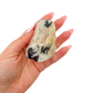 A 172 g rose quartz with tourmaline, the deep pink chunk, resting in an open palm