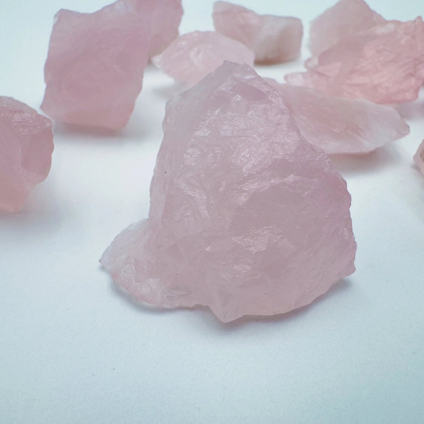 Side profile of Grade AA Rose Quartz raw with natural form and inclusions