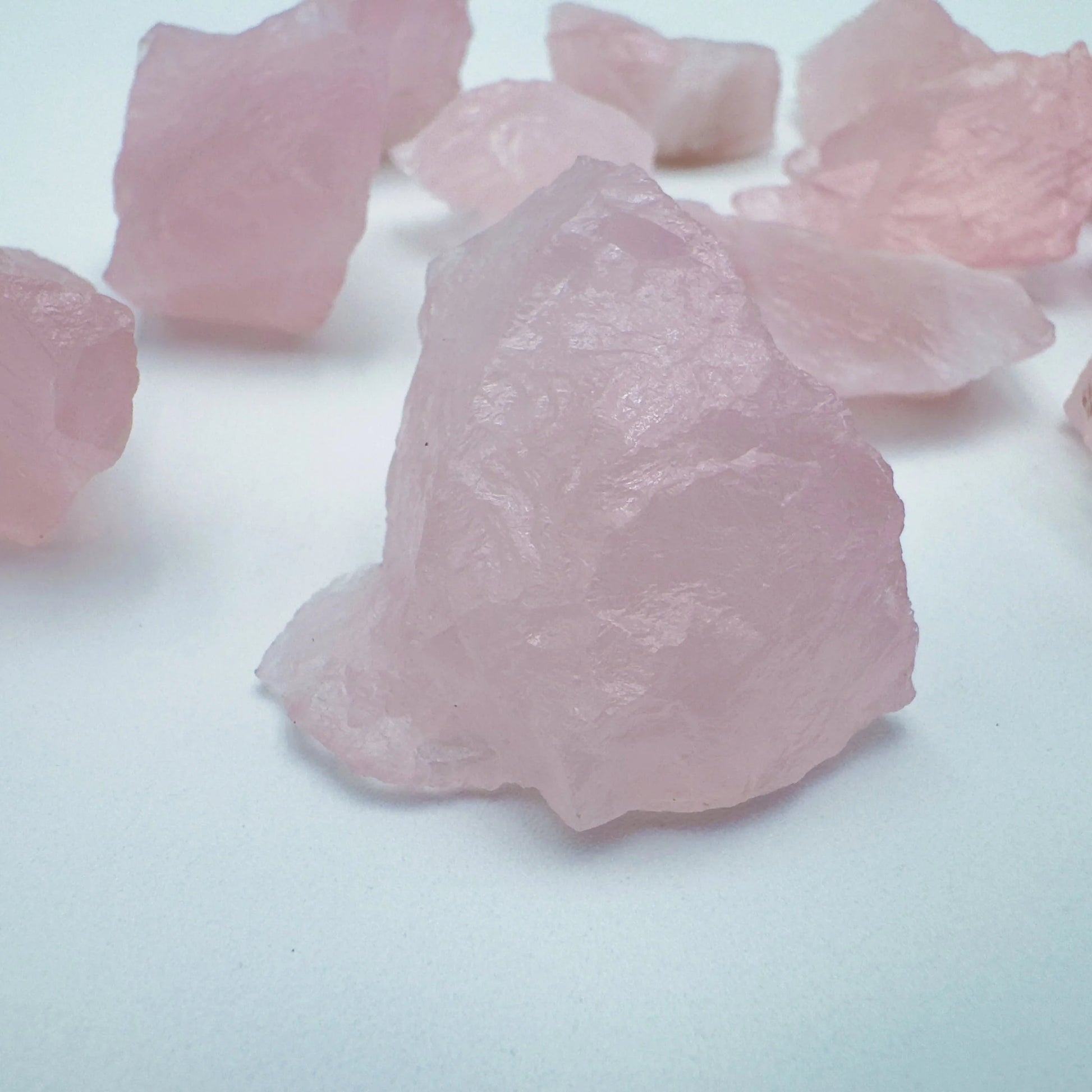 Side profile of Grade AA Rose Quartz raw with natural form and inclusions