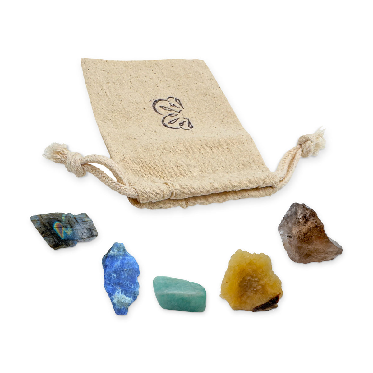 Sagittarius Crystal Kit: labradorite, sodalite, amazonite, septarian and smoky quartz, arranged with the reusable cotton bag they come in, on white