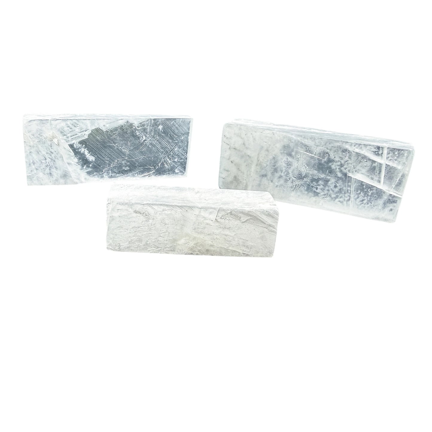Three Selenite sticks laid loosely, showing colour from milky white to translucent