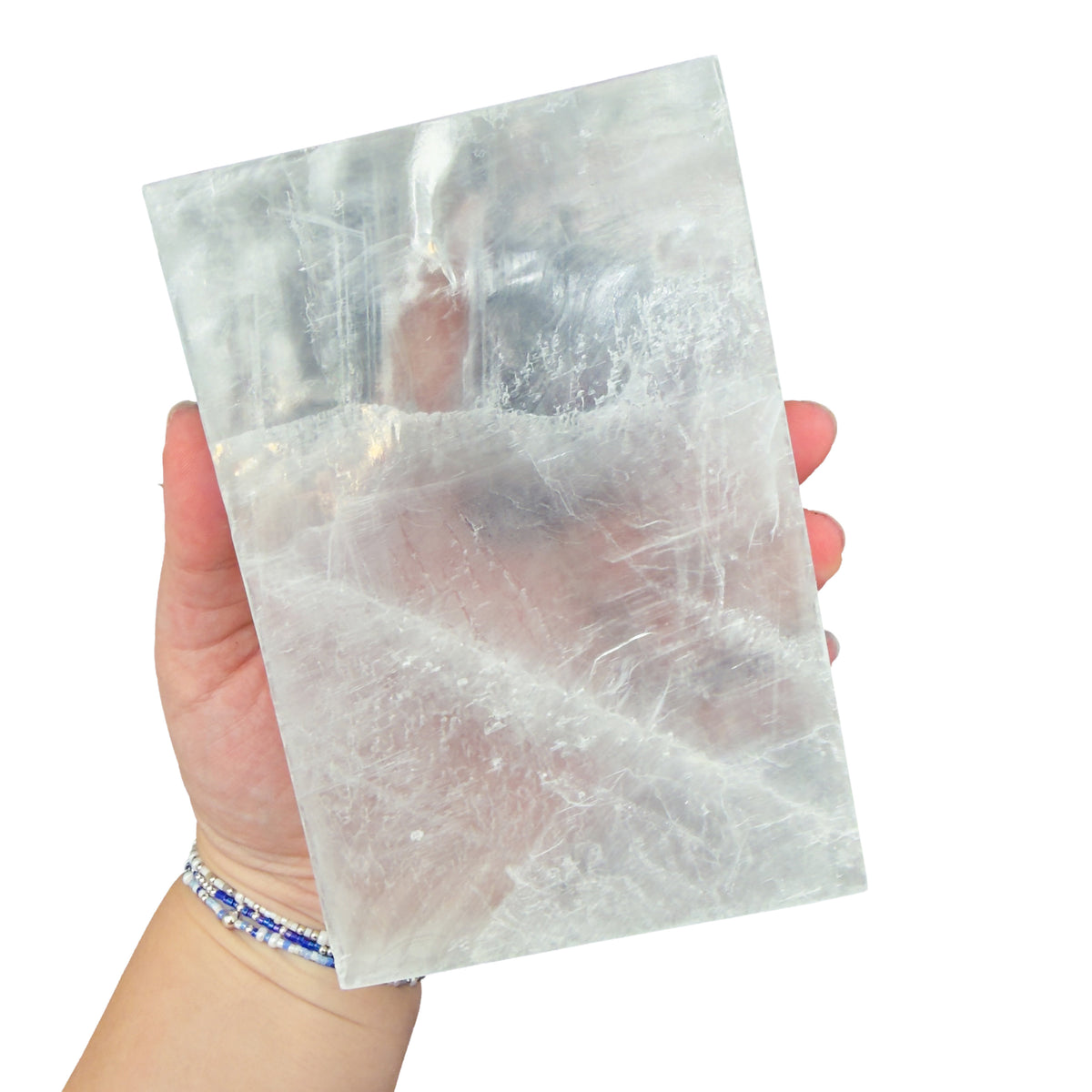 Selenite clearing block from New Mexico held in an open hand, backlit to show translucency, 2.39 pound piece, specimen 65.