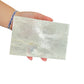 Selenite clearing block from New Mexico held in an open hand, backlit to show translucency, 1.62 pound piece, specimen 69.
