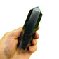 Near view of Shungite polished point, sourced from Republic of Karélia, Russia, showing glassy finish.