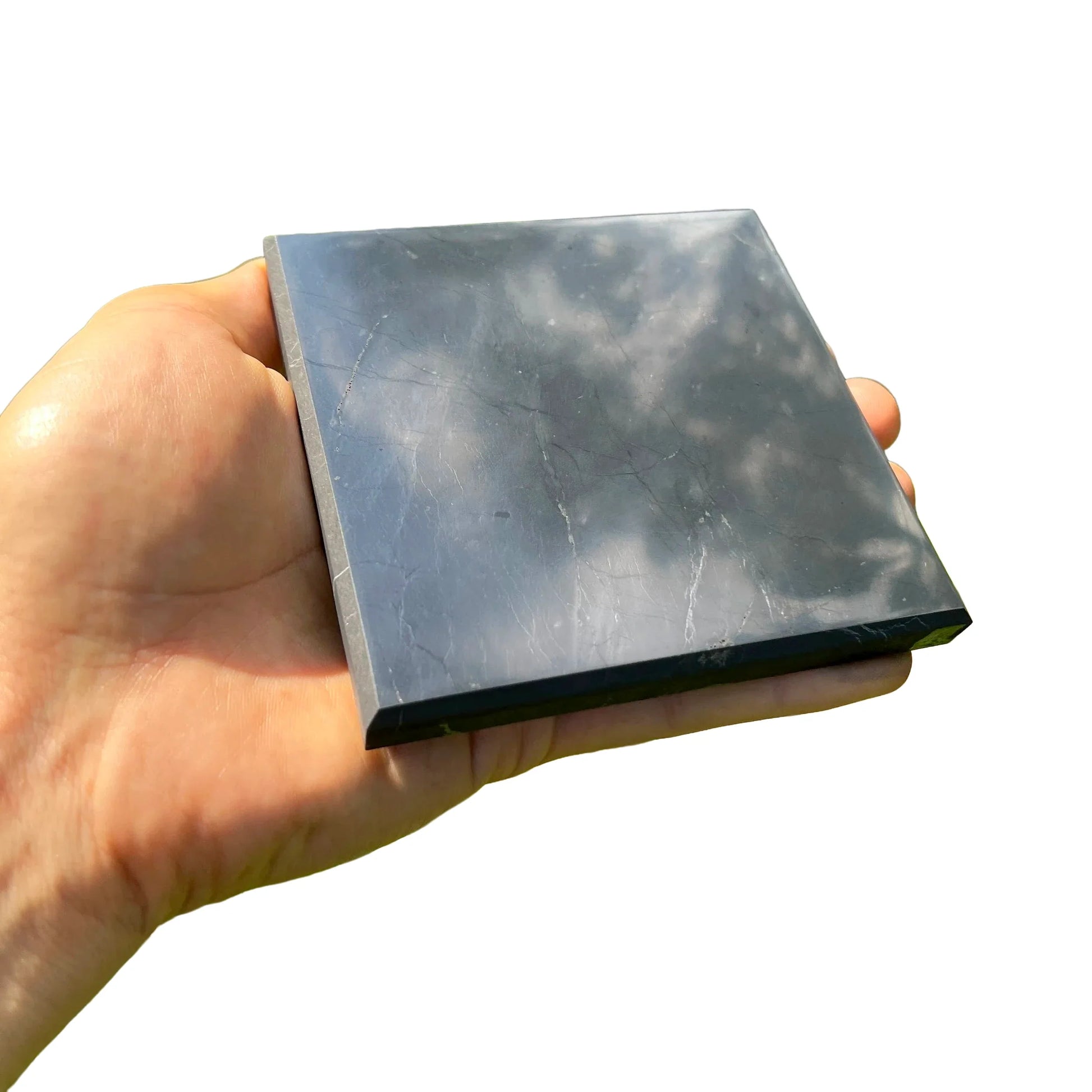 Hand-scale view of Shungite stone, from Republic of Karélia, Russia, in the warmth of daylight.