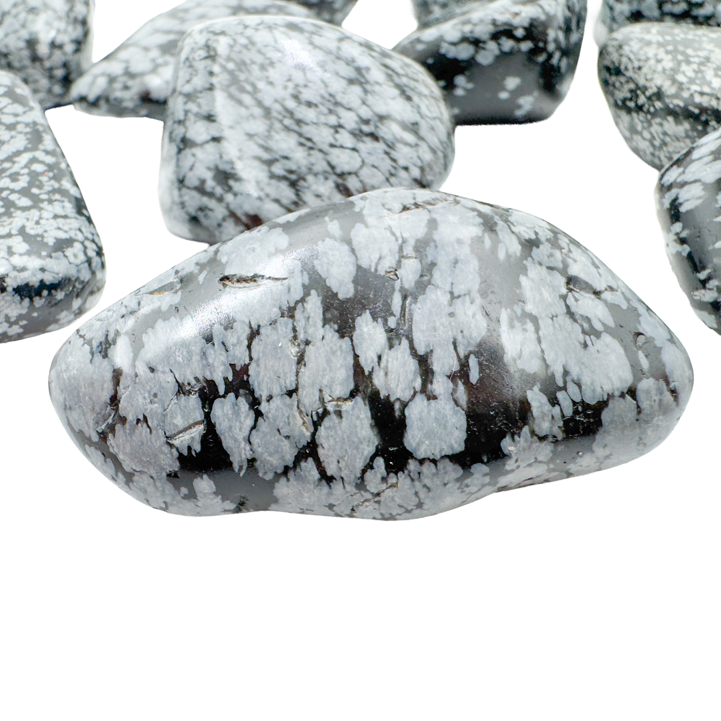 Close view of Snowflake Obsidian tumbled stone showing grey cristobalite snowflakes on black volcanic glass