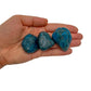 Tabletop view of Apatite tumbled stone, set to give a sense of weight.