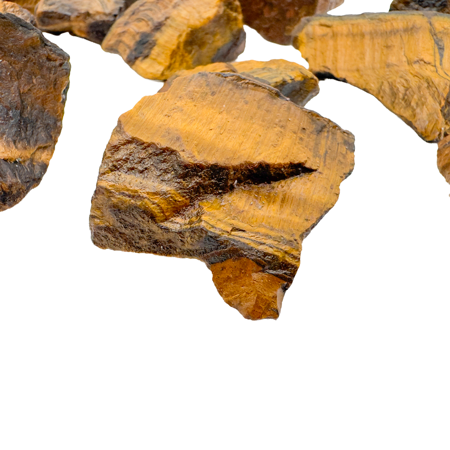 Close view of Tiger Eye raw stones showing golden chatoyant banding on broken faces