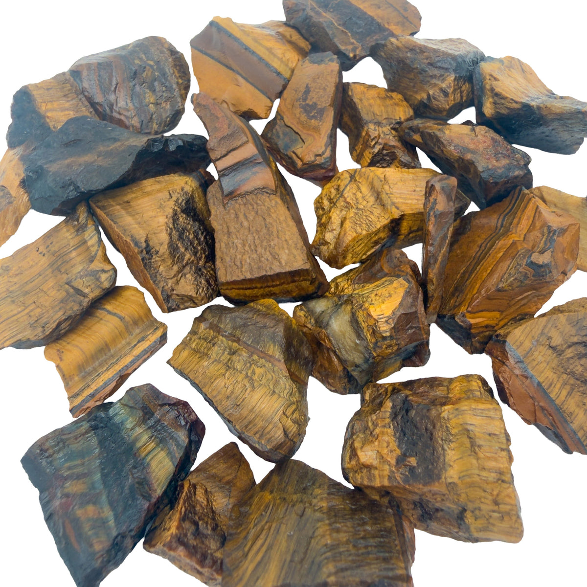 Close view of raw Tiger Eye chunks packed together, with the parallel fiber banding that produces chatoyancy visible across the broken faces.